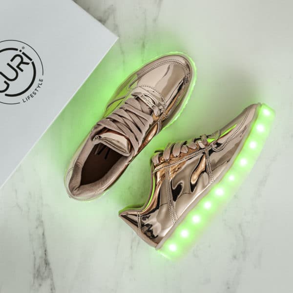 Alternative image of the rose gold shoes for women, with its lights on.